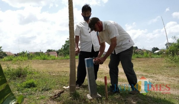 Petugas saat mengukur dan menasang pathok di lahan eks Kali Ngrowo (Joko Pramono for Jatim TIMES)