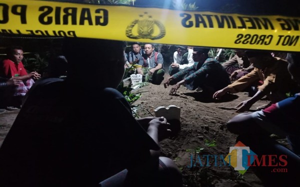 Garis polisi terpasang di makam yang dicuri kain kafannya. (Foto : Adi Rosul / JombangTIMES)