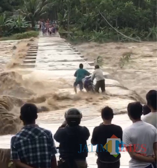 Relawan beserta warga saat berupaya mengevakuasi sepeda motor milik warga ketika musibah banjir terjadi (Foto : PMI Kabupaten Malang for MalangTIMES)