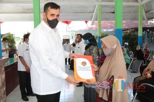 Wali Kota Probolinggo Habid Hadi (kiri) menyerahkan sertifikat kepada warga. (Foto: Mabrur/Probolinggotimes)