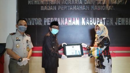 Wakil Bupati Jember Drs. KH. A. Muqit Arief saat menerima piagam penghargaan dari BPN Jember (foto : Izza / Jatim TIMES)