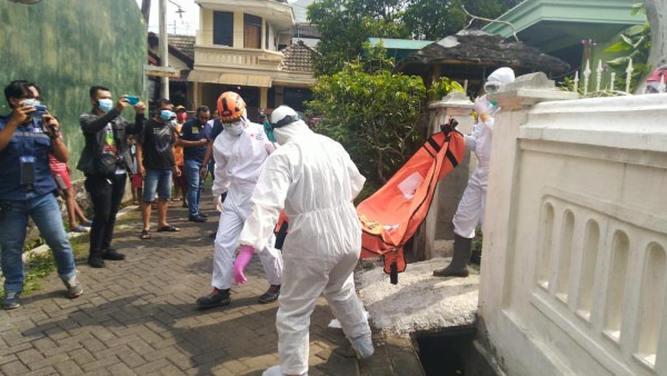 Petugas saat tengah mengevakuasi jasad korban dari dalam rumah. (Ist)