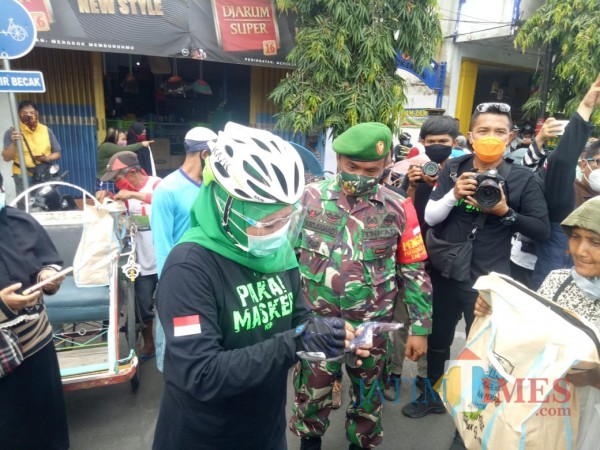 Gubernur Jatim Khofifah ketika menyerahkan sembako di Pasar Baru Lumajang (Foto : Moch. R. Abdul Fatah / Jatim TIMES)