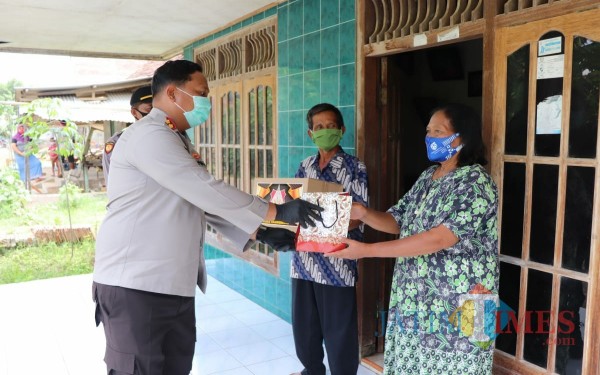 Kapolres Tulungagung AKBP Eva Guna Pandia saat memberikan bantuan pada pasien Covid-19 di Desa Ngranti / Foto : Dokpol / Tulungagung TIMES