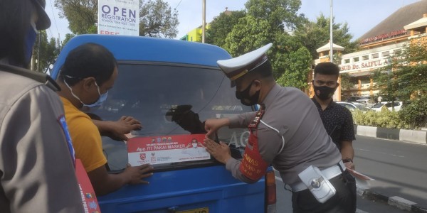 Kasatlantas Polresta Malang Kota AKP Ramadhan Nasution saat melaksanakan penempelan stiker imbauan pada angkutan umum (Ist)