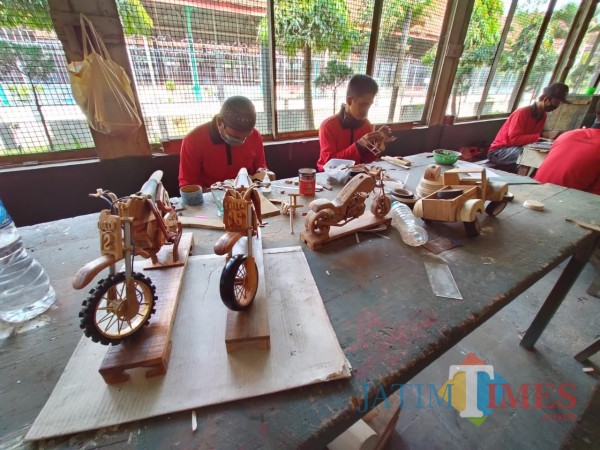 Nampak para napi tengah berada di bengkel seni membuat kerajinan miniatur motor, perahu dan mobil dari kayu (Anggara Sudiongko/MalangTIMES)