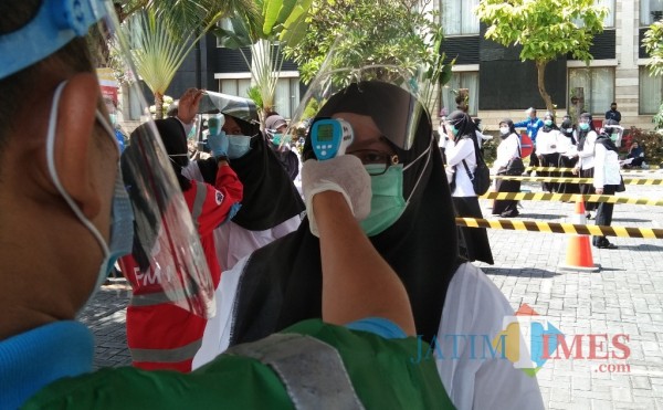 Peserta SKB diukur suhunya sebelum mengikuti ujian SKB (Joko Pramono for Jatim TIMES)