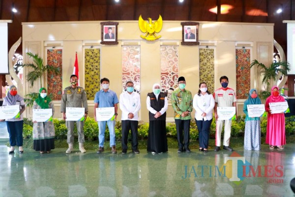 Gubernur Jawa Timur Khofifah Indar Parawansa foto bersama dengan perwakilan penerima bantuan di Pamekasan, (Foto: Rozy/ JatimTimes.com)