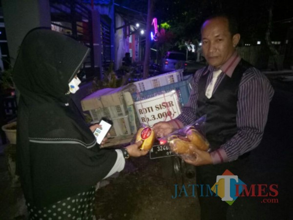 Walau sampai malam hari berjualan, Muhammad Imsyak tetap jaga penampilan (Foto : Moch. R. Abdul Fatah / Jatim TIMES)