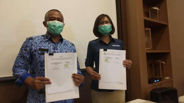 Kepala Disnaker-PMPTSP Kota Malang Erik Setyo Santoso (kiri) dan Kepala BPJS Kesehatan Malang Dina Diana Permata (kanan) saat menunjukkan PKS ke awak media (Pipit Anggraeni/MalangTIMES).
