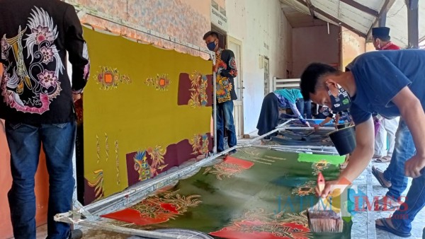Penuh semangat dan kreatifitas, muda-mudi di rumah produksi Batik Rato WMS tampak serius mengerjakan pewarnaan batik (Foto: Syaiful Ramadhani/JatimTIMES)
