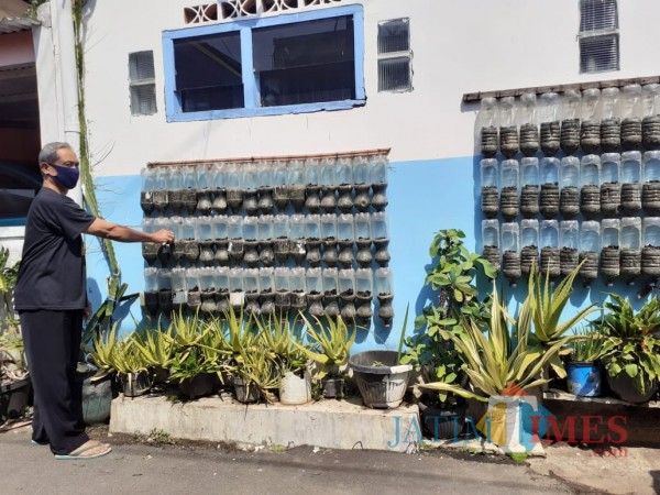 Warga di Kampung DX Patmanam saat merawat tanaman hijau di area depan rumahnya. (Arifina Cahyanti Firdausi/MalangTIMES).