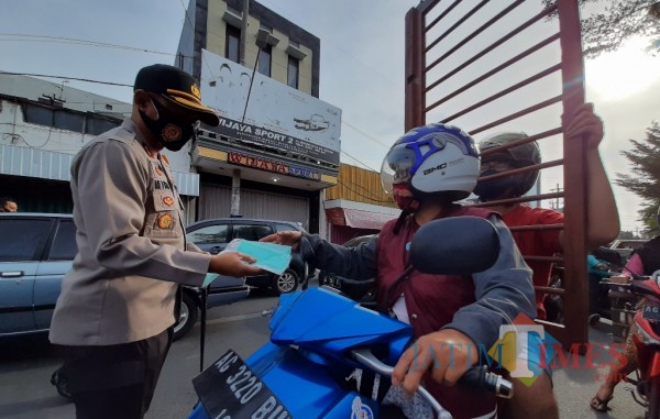 Kapolresta Kediri AKBP Miko Indrayana membagikan masker kepada pengguna jalan. (Eko Arif S/ JatimTIMES)