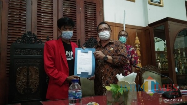 Bupati Tulungagung Maryoto Birowo menunjukkan permohonan penolakan UU Cipta Kerja yang diajukan mahasiswa. (foto : Joko Pramono/Jatim Times)
