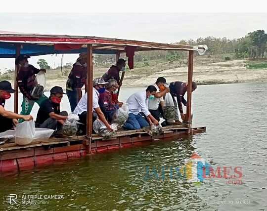Pasangan calon bupati dan wakil bupati Ngawi Ony Anwar dan Dwi Riyanto Jatmiko menebar ribuan benih ikan di perairan Waduk Pondok.