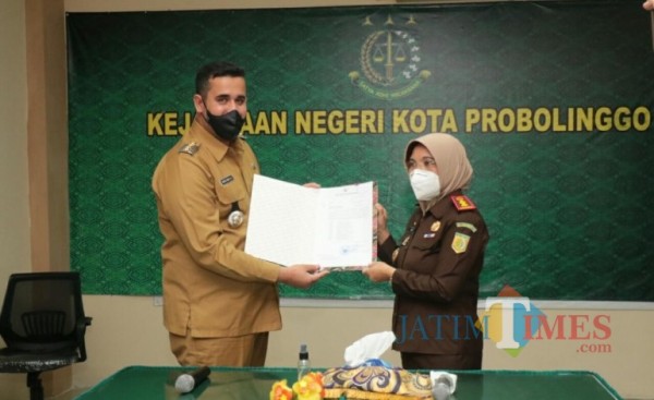 Kepala Kejaksaan Negeri (Kejari) Kota Probolinggo (kanan) saat terima penghargaan dari Wali Kota Probolinggo. (Foto: Bilhaq Nazal/ProbolinggoTimes)