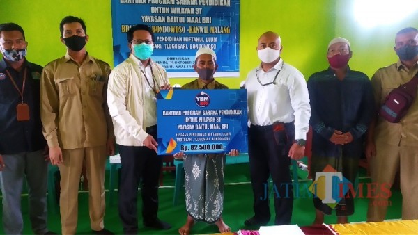 Ketua Yayasan Miftahul Ulum saat menerima bantuan (Foto: Abror Rosi/JatimTimes)