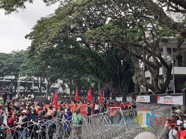 Massa aksi unjuk rasa tolak Omnibus Law UU Cipta Kerja mengepung kawasan depan Gedung DPRD Kota Malang, Selasa sore (20/10). (Arifina Cahyanti Firdausi/MalangTIMES).