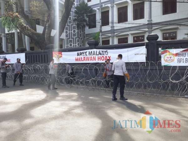 Petugas saat memasang kawat beruduri di sepanjang gedung DPRD Kota Malang. (Arifina Cahyanti Firdausi/MalangTIMES).