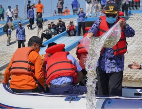 Wali Kota Madiun Maidi saat melepas 136 ribu benih ikan dari atas kapal. (Foto: Dokumen JatimTIMES)