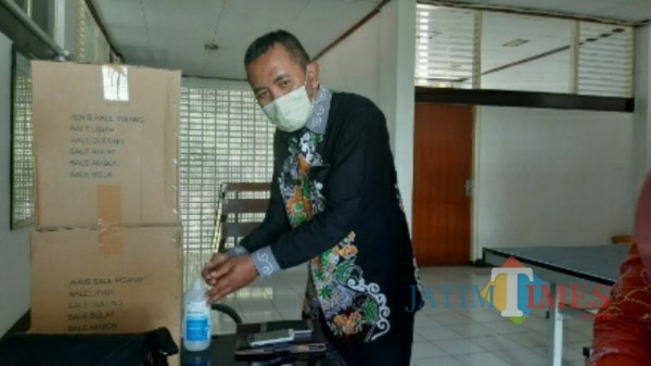 Kabag Humas Pemkab Bondowoso Suryadi sedang mencuci tangan. (Foto: Dokumen JatimTIMES)