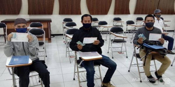 Pegawai yang terkena PHK lantaran pandemi covid-19 saat menerima bantuan tunai dari Disnaker-PMPTSP Kota Malang. (Disnaker-PMPTSP Kota Malang for MalangTIMES).