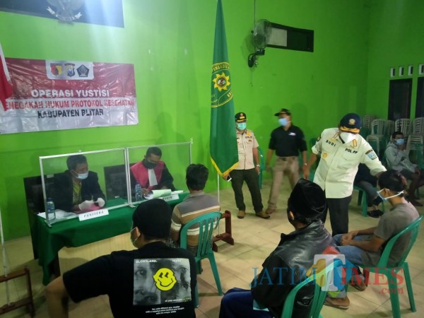 Pjs Bupati Blitar Budi Santosa (baju putih) memberikan sosialisasi 3M kepada warga yang melanggar prokes.(Foto : Aunur Rofiq/BlitarTIMES)