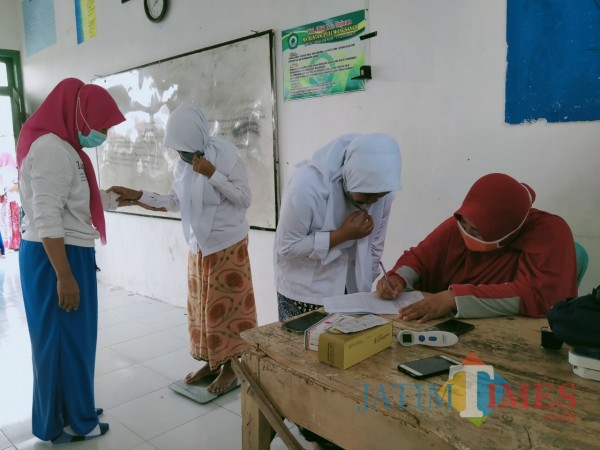 Petugas LKNU Pamekasan saat melakukan pemeriksaan kesehatan kepada para santri. (Foto:Rozy/JatimTimes.com)