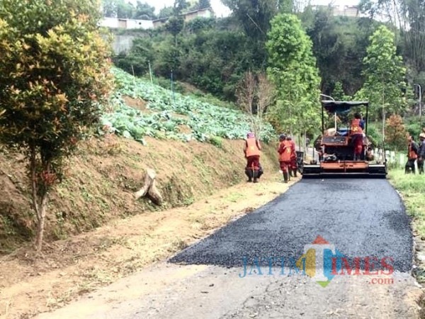 Petugas saat melakukan pengaspalan di Dusun Brau, Desa Gunungsari, Kecamatan Bumiaji. (Foto: Dokumen JatimTIMES)