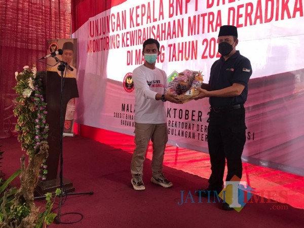 Kepala BNPT RI, Boy Rafli Amar (baju hitam) saat menerima bingkisan makanan ringan produksi dari Syahrul Munif (baju putih), Senin (26/10/2020). (Foto: Dok. JatimTimes)
