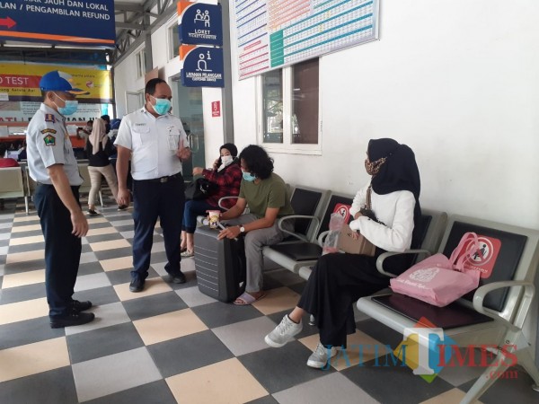 Kabid Angkutan Dishub Kota Malang Sony Bachtiar (bertopi) saat menegur calon penumpang untuk jaga jarak di Stasiun Malang, Selasa (27/10). (Arifina Cahyanti Firdausi/MalangTIMES).