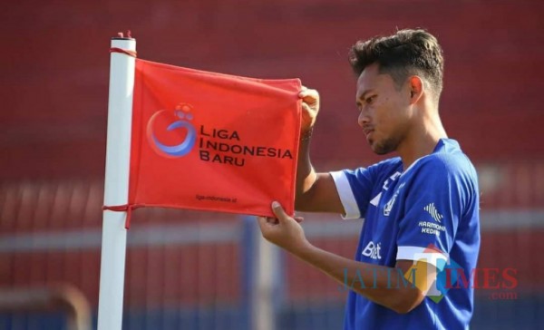 Salah satu pemain Persik Kediri saat memegang bendera LIB.(ist)