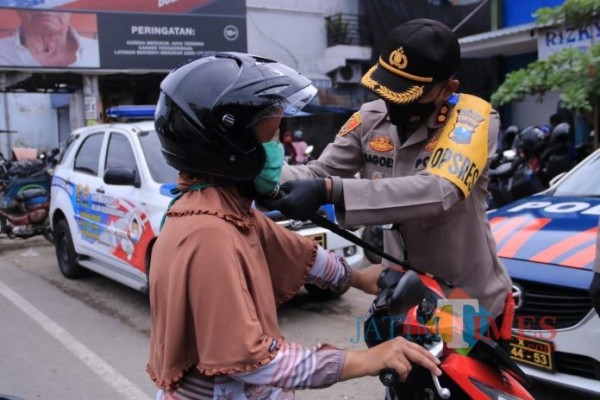 Kapolres Madiun saat memberikan Helm kepada salah satu pengendara.