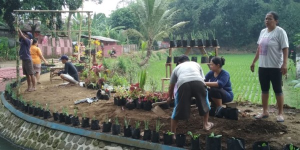 Masyarakat dan tim pengmas prodi HI FISIP UB sedang melakukan penataan konsep ecotourism di pinggir sungai. (Foto: Tim Pengmas Prodi HI FISIP UB)
