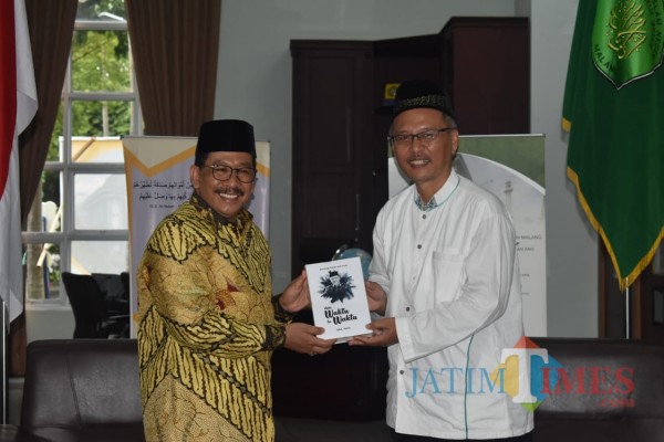 (dari kiri) Wamenag RI Drs H Zainut Tauhid Sa'adi MSi saat menerima buku puisi dari Rektor UIN Malang Prof Dr H Abdul Haris MAg. (Foto: Humas UIN Malang)