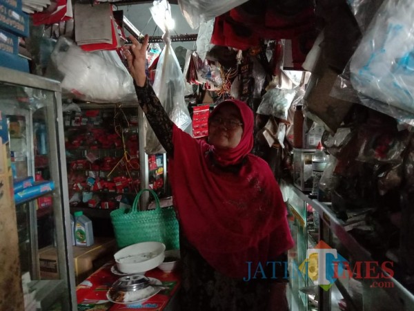 Umi Kalsum, pemilik bengkel saat mengecek barang di bengkelnya. (Anggara Sudiongko/MalangTIMES)