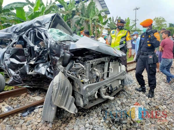 Polisi mengevakuasi bangkai mobil yang terlibat kecelakaan dengan KA di Blitar.