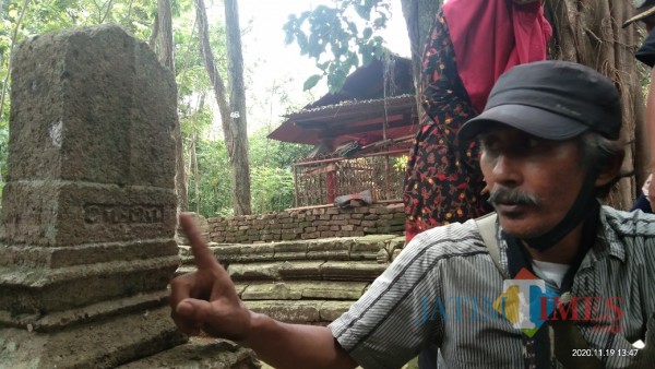 Dwi Cahyono saat menunjukkan makam kuno di Situs Astono Gedong (Joko Pramono/ JatimTIMES)