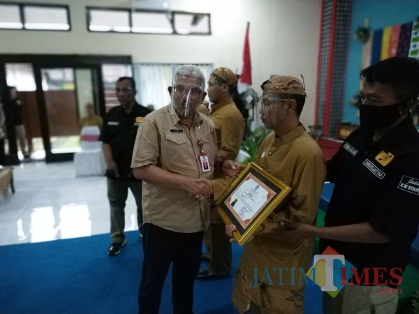 Kepala Dinsos Jatim, Dr Alwi saat memberikan sertifikat kepada klien (Hendra Saputra)