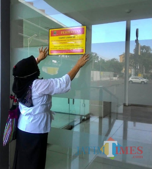 Petugas Bapenda Kota Malang saat menempel stiker kepada WP nakal (istimewa)