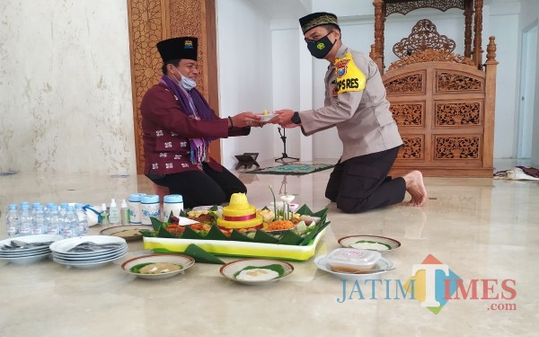 Ustazd H. Soim Alkasi memberikan potongan tumpeng ke AKBP Handono Subiakto / Foto : Anang Basso / Tulungagung TIMES