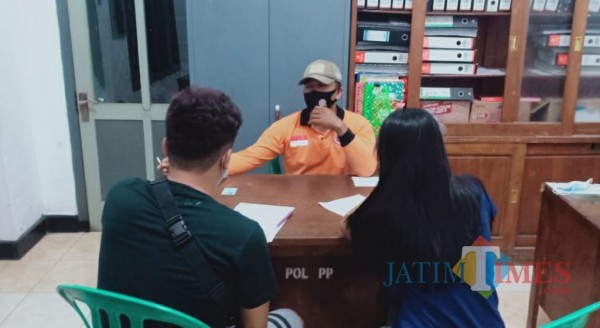 Pasangan bukan suami istri saat dimintai keterangan di kantor satpol PP. (eko arif s/Jatimtimes)