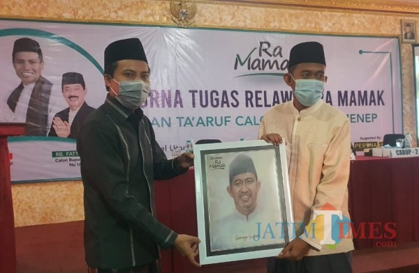 KH. Mohammad Salahuddin A. Warits, atau Ra Mamak sewaktu memberikan cindera mata pada Cabup Achmad Fauzi (Foto: Ist/Jatim TIMES)