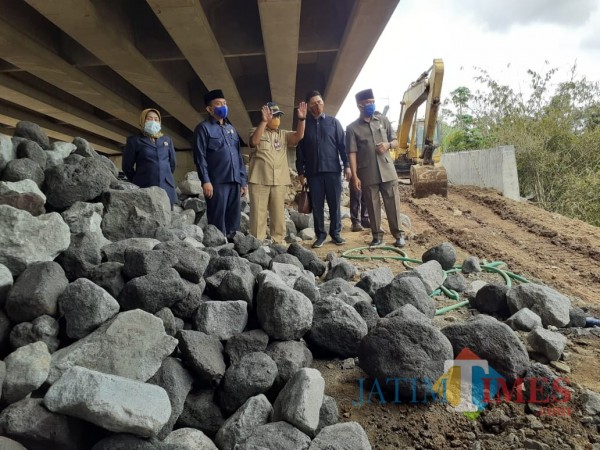 Komisi C DPRD Kota Malang didampingi Kepala DPUPR Kota Malang Hadi Santoso (bertopi) saat melakukan tinjauan ambrolnya plengsengan di proyek pembangunan Jembatan Kedungkandang, Selasa (24/11). (Arifina Cahyanti Firdausi/MalangTIMES).