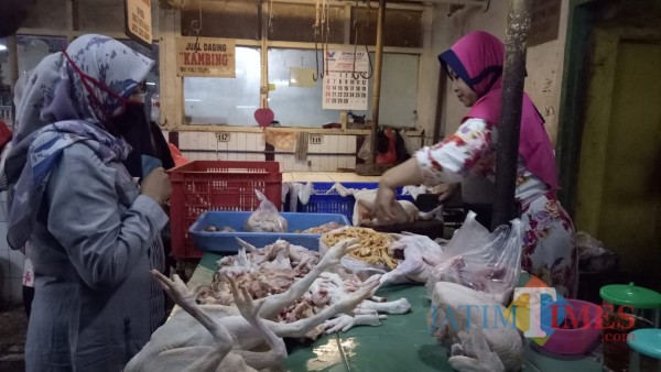 Penjual daging ayam potong saat melayani pembeli di Pasar Besar Kota Malang. (Ahmad Amin/MalangTIMES).