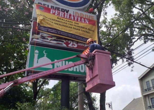 Pemasangan papan peringatan oleh petugas pada objek pajak yang masih menunggak. (Dokumentasi Bapenda Kota Malang).