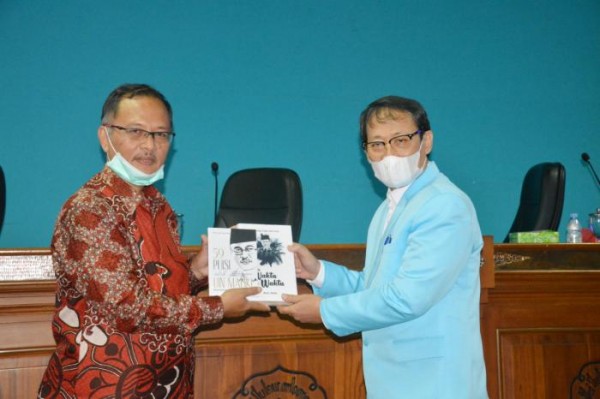 Rektor UIN Malang Prof Dr Abdul Haris MAg (kiri) memberikan buku puisinya kepada Ketua Senat Akademik UNS Prof Dr Adi Sulistiyono SH MH. (Foto: Humas)