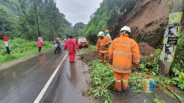 Petugas saat melakukan pembersihan tanah longsor di Jalan Raya Sumber Brantas, Desa Sumber Brantas Kecamatan Bumiaji, Minggu (29/11/2020). (Foto: istimewa)