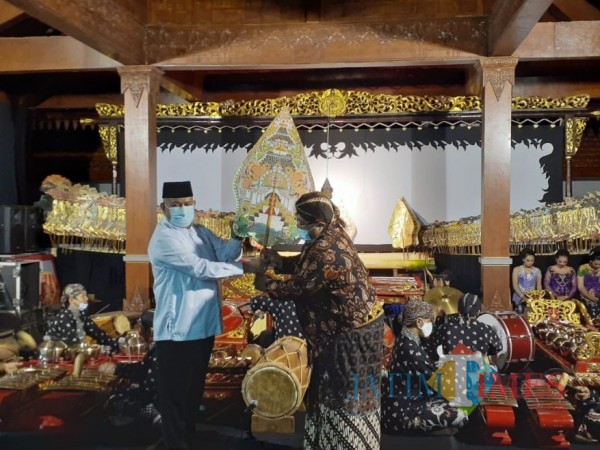 Momen saat Pjs Bupati Malang, Sjaichul Ghulam menerima wayang gunungan dari dalang Ki Setiyo Wahyudi di Museum Singhasari, Sabtu (28/11/2020) malam. (Foto: Dok. JatimTimes)