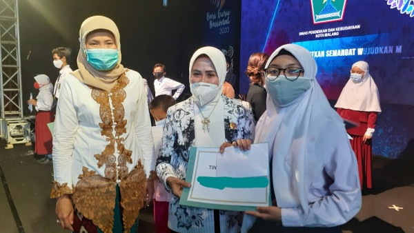 Kepala Disdikbud Kota Malang, Dra Zubaidah MM (tengah) memberikan penghargaan kepada Najwa Aurora Mahsya (paling kanan). (Foto: istimewa)
